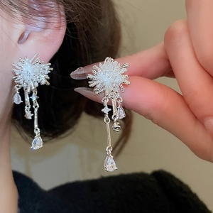 Macro view of silver tassel earrings with zircon fireworks design and white pearls