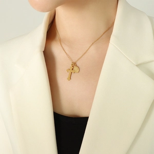 Collier rétro avec pendentif croix et pièce ovale en acier titane doré sur mannequin