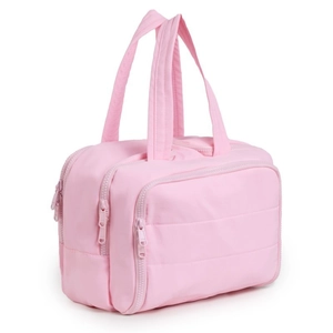 Pink quilted travel toiletry bag with double main zippers and front pocket on white background