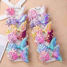 Close-up of mermaid themed hair clips with sequins fish tail and seashell on display card