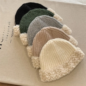 Detail showing five colors of chunky knit winter hats with thick faux fur lining