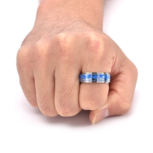 Macro d'une bague rotative pour homme en acier avec émail bleu et motifs de dauphins