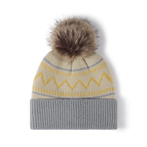 Winter knit beanie for women with pompom and yellow wavy stripes on a beige background