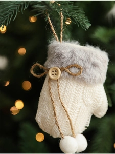 Close-up of white knitted Christmas glove ornament with grey faux fur and wood button detail