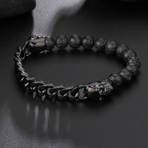Détail des perles tête de mort et pierres de lave sur un bracelet à maille gourmette