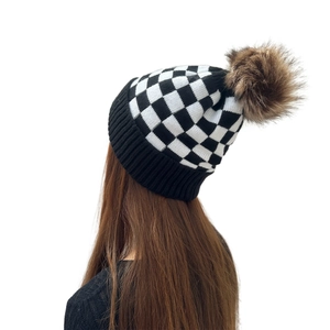 Women's checkerboard knit beanie with large faux fur pompom for winter outdoor warmth