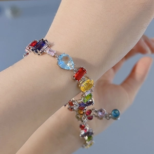 Detail of colorful multi-shape crystal Gema bracelet worn on wrist with silver chain