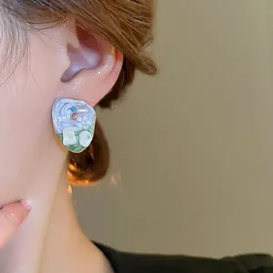 French vintage oil painting style earrings with small flowers and pearls worn by a model