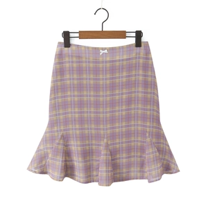 Detail of ruffle fish-tail hem mini skirt with purple plaid and white bow