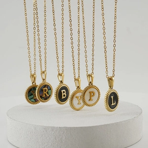 Detail of gold titanium steel necklaces with colorful shell letter pendants Y R B L P