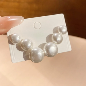 Detail view of a V-shaped pearl arrangement with gradient sizing on a sleek gold base