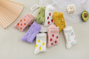 Flat lay of soft mink velvet winter socks with various fruit patterns and cozy decor