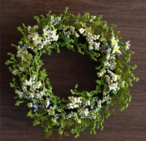 Detailed close-up of mixed artificial berries and white flowers on a wooden surface