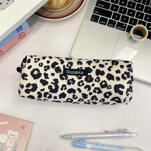 Macro shot of a canvas leopard print pencil case with black zipper on a modern office desk