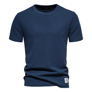 Close-up of deep blue waffle knit fabric texture and round neckline on men's cotton t-shirt