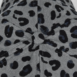 Macro view of leopard print corduroy texture and top button on a six-panel baseball cap