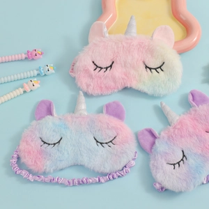 Detail of plush unicorn sleep masks in pink, blue, and purple gradient tie-dye fabric