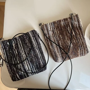 Close-up of textured knit crossbody phone bags with woven patterns and slim cords