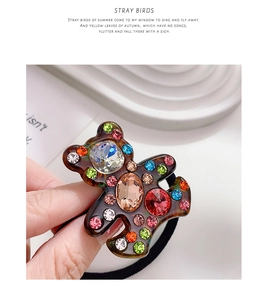 Detailed close-up of tortoise acetate bear hair tie with sparkling colorful rhinestones