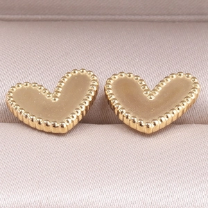 Detailed close-up of golden heart-shaped stud earrings with vintage milgrain bead edges
