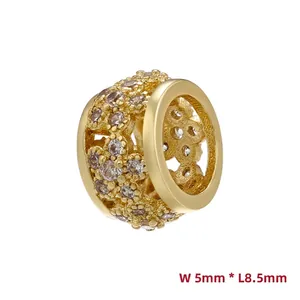 Macro detail of 18K gold plated charm with hollow flower pattern and zircon inlay