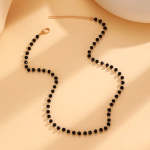 Close-up of gothic black beaded necklace with faceted crystals and golden lobster clasp