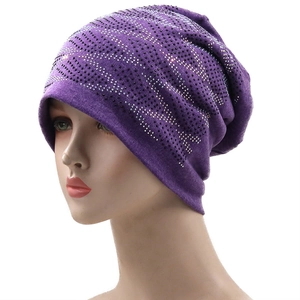 Detail of purple knitted beanie featuring sparkling rhinestone wave patterns on soft fabric