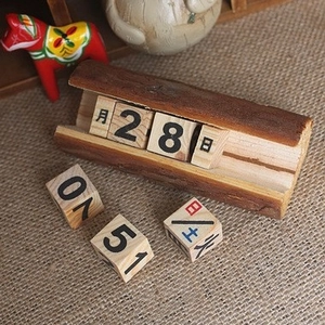 Calendrier perpétuel en bois de style européen avec cubes sur un bureau rustique