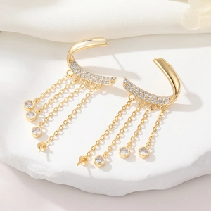 Elegant C-shaped gold tassel earrings with zircon studs and dangling chains on stone tray