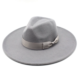Detail of grey wool fedora hat with flat wide brim and decorative satin ribbon bow