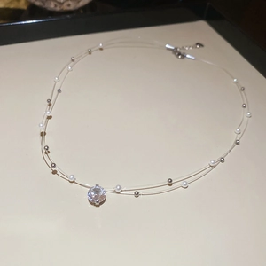 Detailed macro of a double-layer zircon and pearl necklace with transparent fishing wire