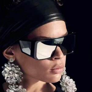 Close-up of retro oversized shield sunglasses and sparkling crystal floral earrings