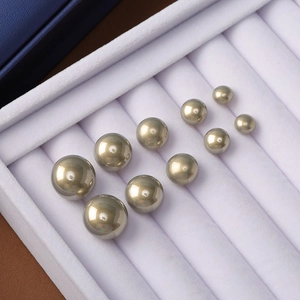 Macro view of metallic champagne gold faux pearls in multiple sizes for elegant jewelry making