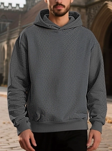 Detail shot of men's dark grey hooded sweatshirt with geometric knit jacquard texture