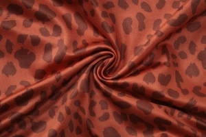 Vue macro d'un tissu imprimé léopard brun-rouge avec texture de tricot côtelé
