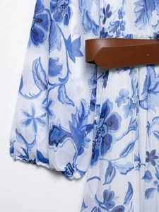 Detail of blue floral chiffon dress featuring elastic cuffs and a brown leather belt