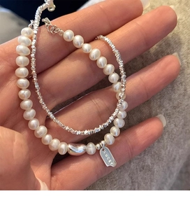 Macro detail of s925 silver LUCKY tag with freshwater pearls and silver beads bracelet