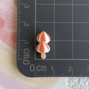 Détail macro de l'accessoire miniature en résine de 1,5 cm en forme de petit champignon