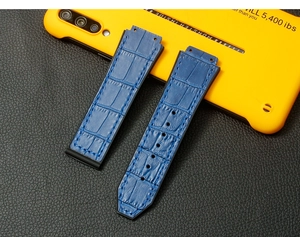 Detail of dark blue crocodile pattern leather strap with black rubber base and H-shaped holes