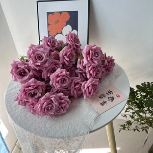 Detailed view of pink silk artificial roses on a lace tablecloth in a romantic setting