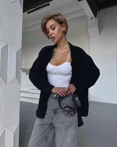 Close-up of high-waist wide-leg grey denim jeans paired with a black shirt and white tank top