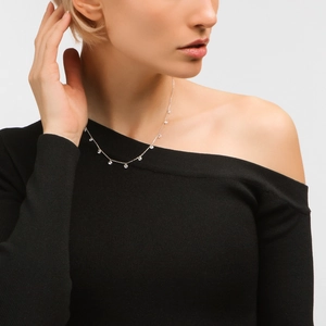 Close-up of S925 silver station necklace with sparkling zircon drops on female model