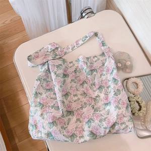 Detalle de bolso tote de algodón floral con estampado de rosas moradas en fondo blanco