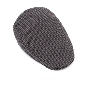 Top view of classic coffee and white plaid pattern on the vintage flat cap fabric