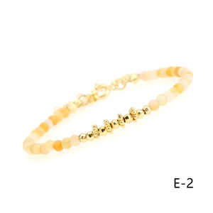 Macro detail of natural carnelian beaded bracelet with gold plated spacers and lobster clasp