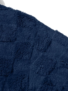 Macro detail of navy blue flannel fabric with textured checkered embossed patterns