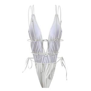 Dettaglio del costume intero bianco testurizzato con tagli e lacci decorativi