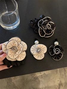 Detail of camellia hair scrunchies with white pearls and contrast piping finish