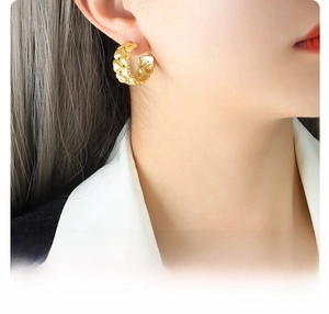 Detail of 18k gold plated titanium heart earrings worn to show size and luster