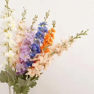 Vibrant multicolored artificial delphinium flowers set against a clean white background